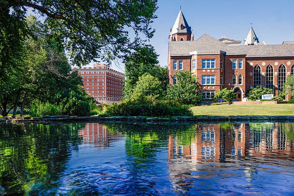 Campus beauty shot of Cook Hall Cook school exterior with water in foreground