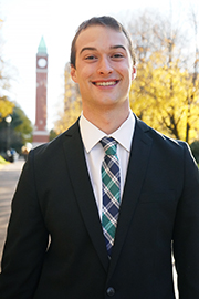 Ben Kemper A headshot of Ben Kemper with a clocktower and trees in the background.