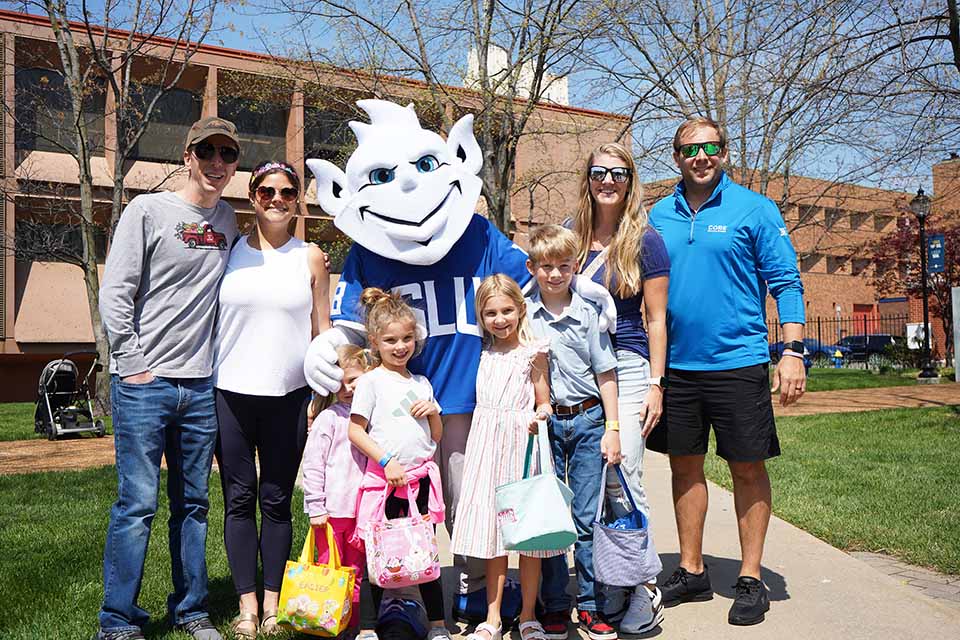 The Billiken poses for a photo with a family at the Easter Egg Hunt.