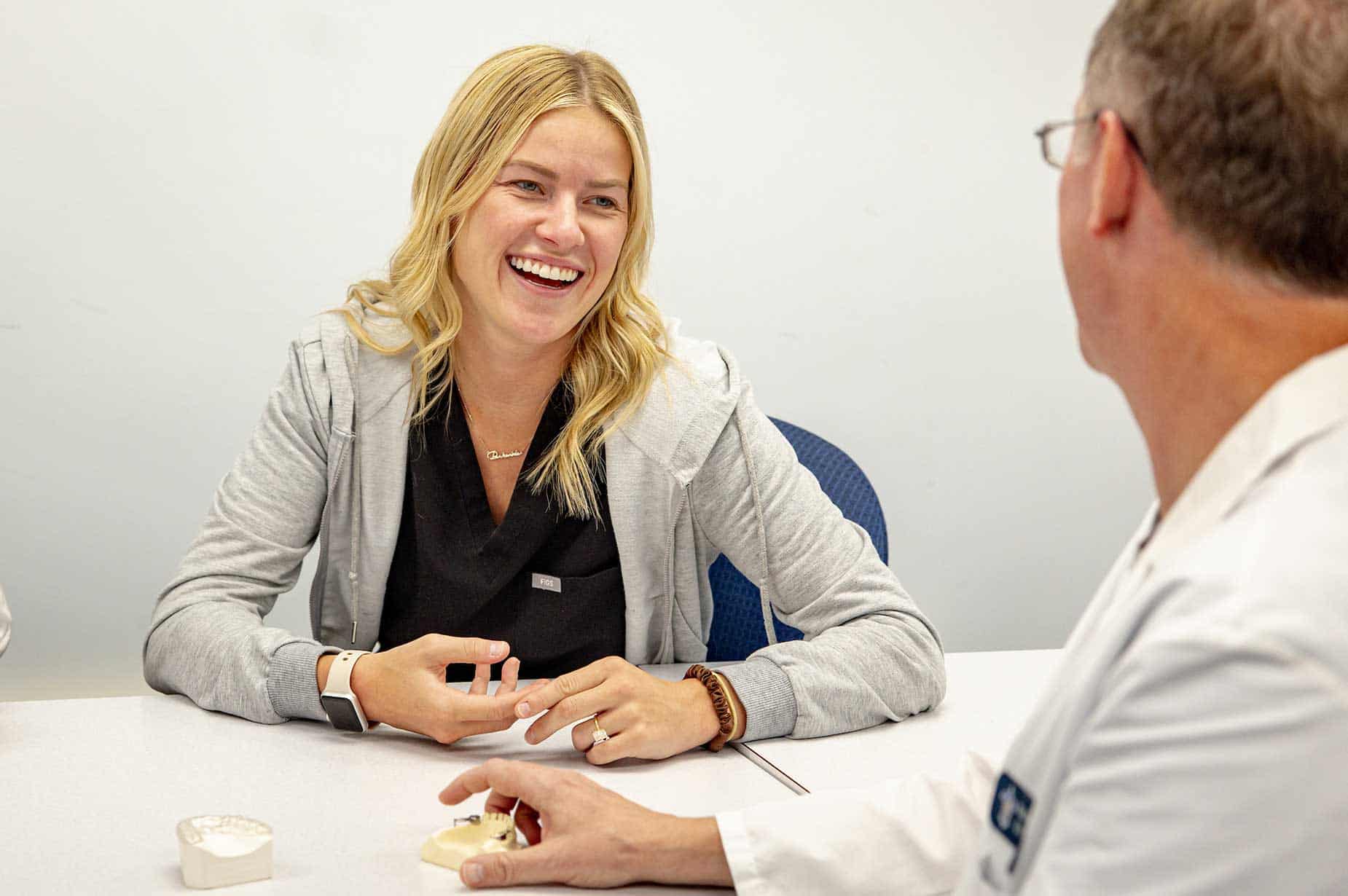 A female resident chats and laughs with a male CADE faculty member.