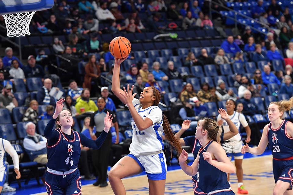 Women's basketball A women's basketball player shoots a basket.
