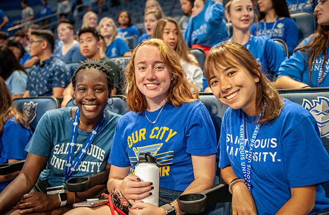 Three new freshman students sitting in the stands at Chaifetz Arena at convocation