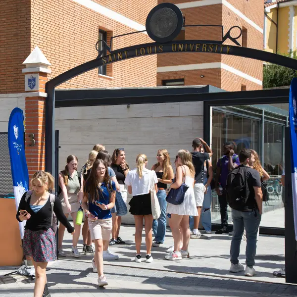SLU students stand and mingle near the gateway of the SLU-Madrid campus.