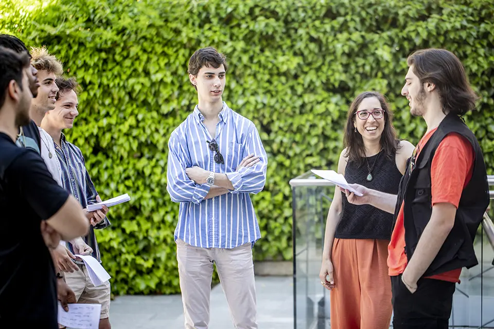 A group of students and the teacher standing in an outdoor classroom.
