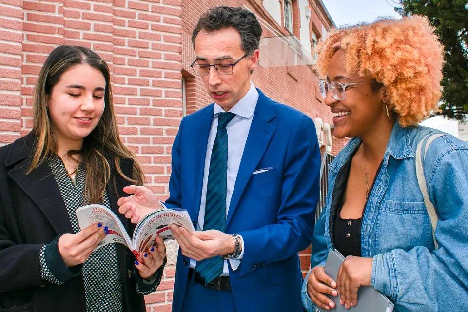 A professor works talks with a male student in a SLU-Madrid classroom.