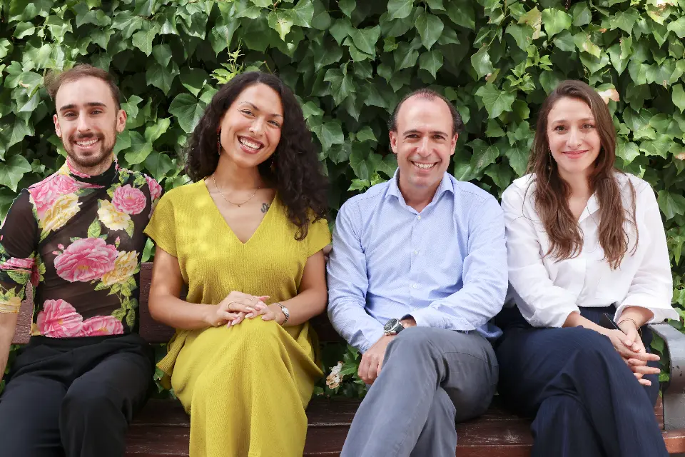 The members of SLU-Madrid counseling team pose for a group photo in front of blossoming trees.