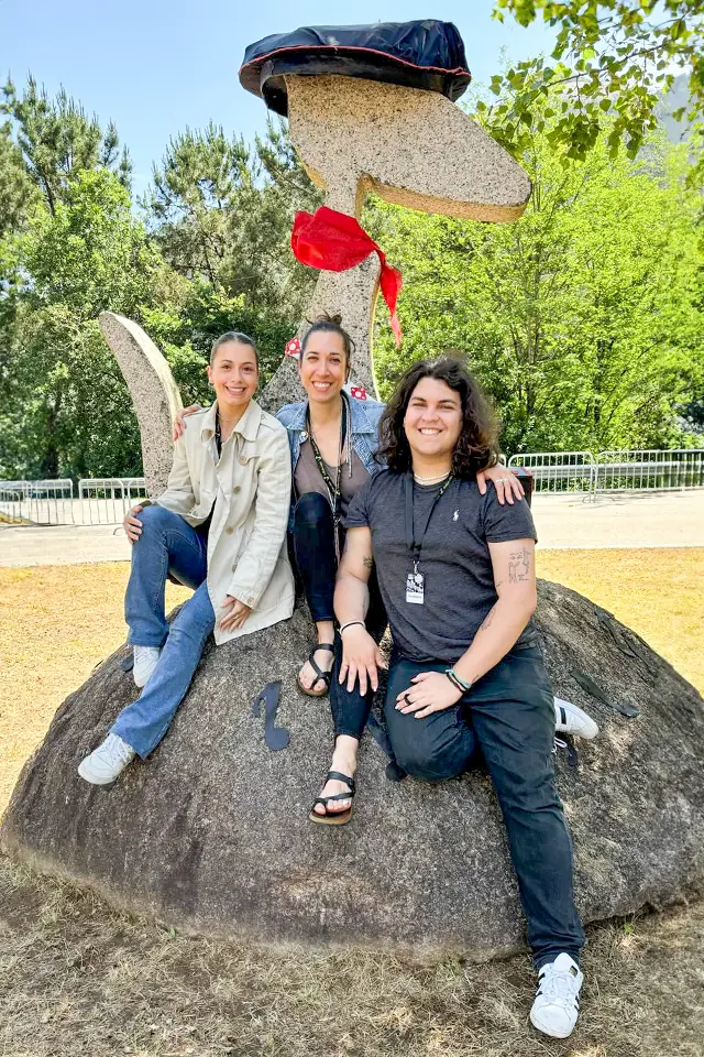Lara Mitchell Guirao, Rosana Vivar and Ernesto Lange Rooks Two students and a professor pose while sitting on a rock with a sculpture made of rock behind them.