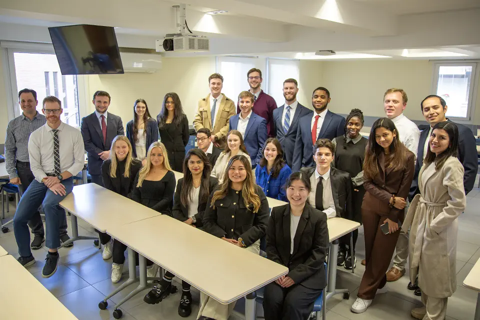 Brad Carlson, Ph.D. (seated on table in front) with OYMBA participants in a San Ignacio Hall classroom.