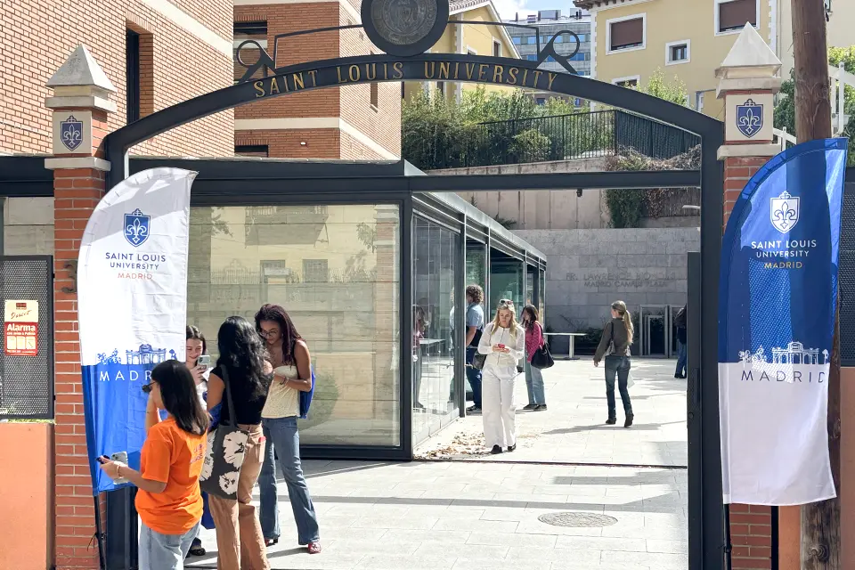 SLU-Madrid Welcomes Class of 2029 Two banners with university logo on both sides of entrance with an arch that reads “Saint Louis University”. Students can be seen in interior patio past the entrance.