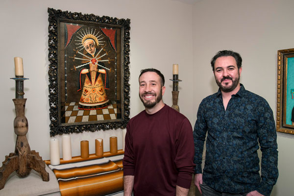 Vicente Telles and Brandon Maldonado Artists Vicente Telles and Brandon Maldonado stand in front of a painting of Our Lady of Sorrows in a MOCRA side chapel gallery