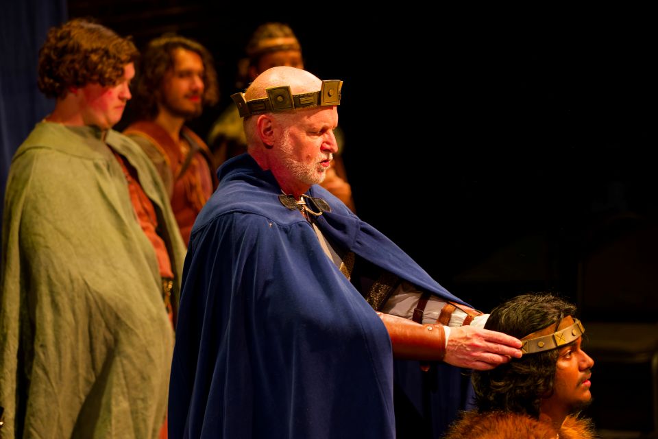 a man wearing a crown and cape