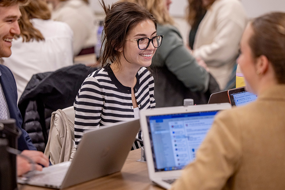 Four students in professional clothing stand and talk outside of SLU Hospital