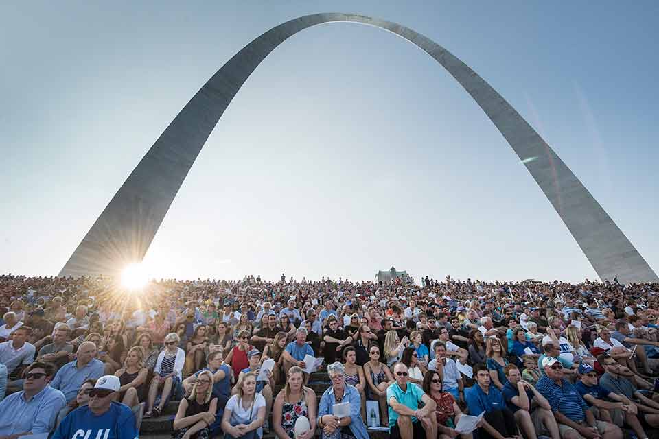 Mass attendees sit on the stairs in front of the Arch during SLU's celebratory Bicentennial Mass. 